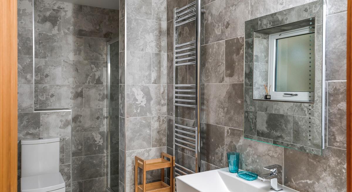 The marble effect tiles and modern fixtures give the ensuite an indulgent, spa-like feel.