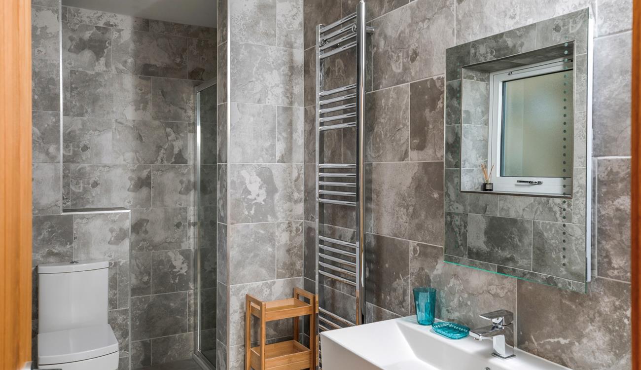 The marble effect tiles and modern fixtures give the ensuite an indulgent, spa-like feel.