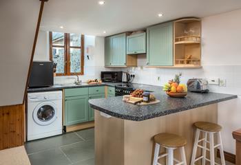 The open plan kitchen area is well-equipped with all you need to rustle up tasty meals.