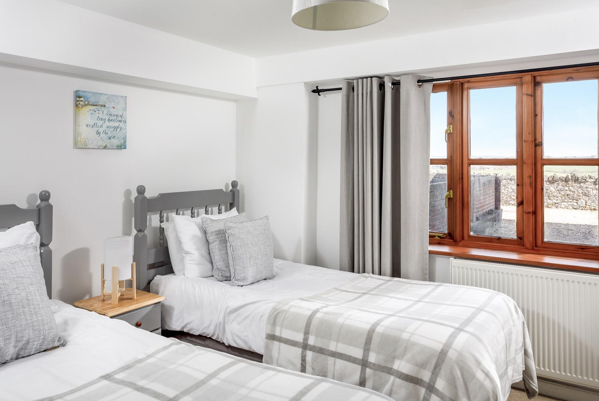 Calming grey decor makes the twin bedroom a real home from home, perfect for children and young adults.