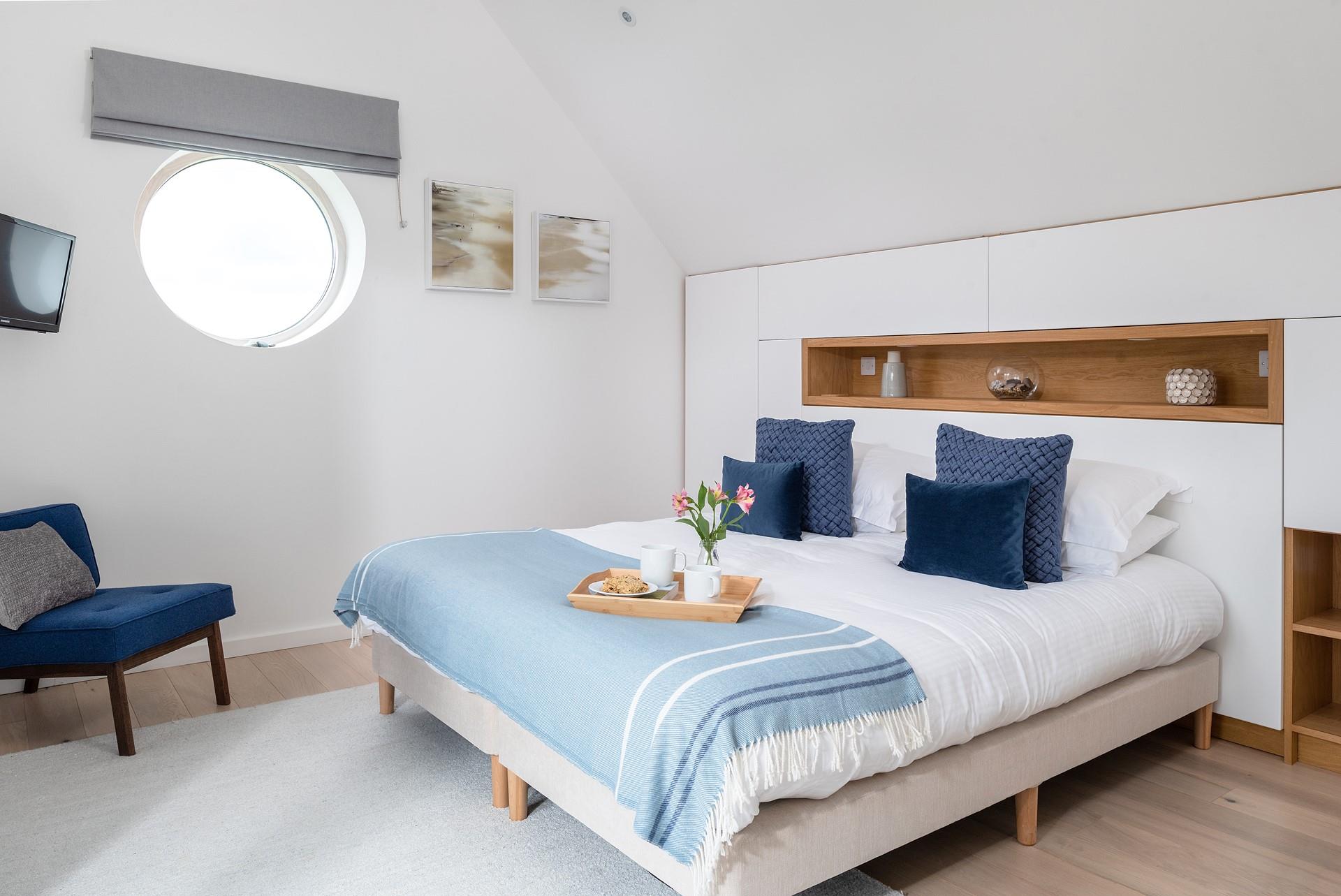 Nautical touch to the master bedroom with a porthole window.