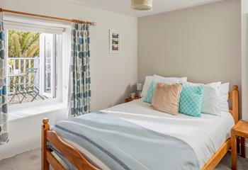 Bedroom 4 with comfortable double bed, looks out onto the balcony and garden.