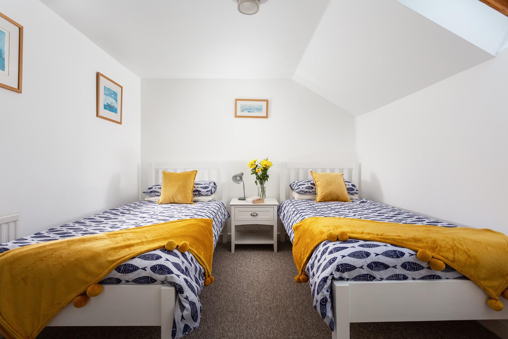 Slanted walls and a skylight window enhance the room's cosy feel, making it a perfect choice for both children and young adults.