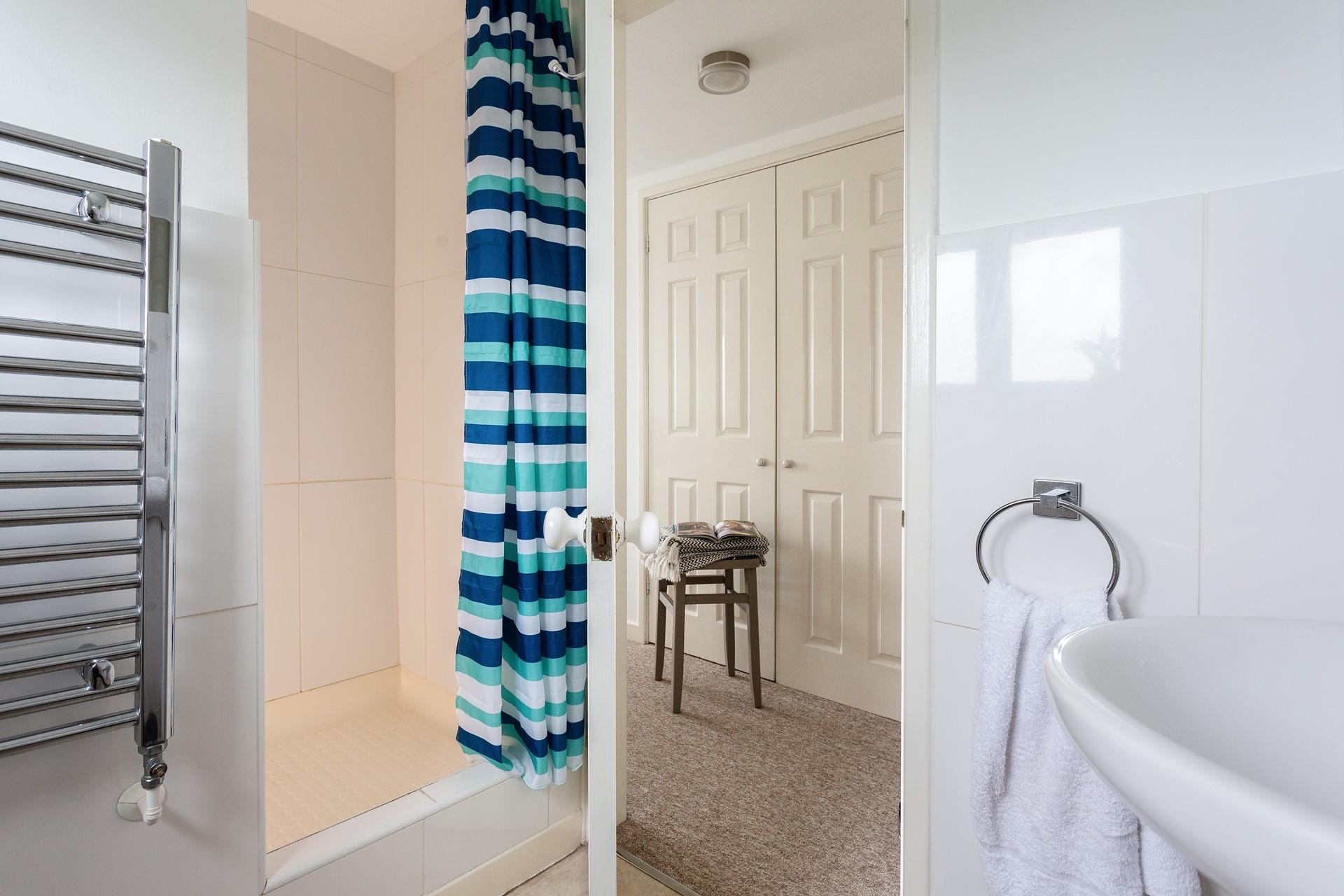 Fresh white tiles and practical furnishings have created a lovely space to start your day or freshen up before a night out.