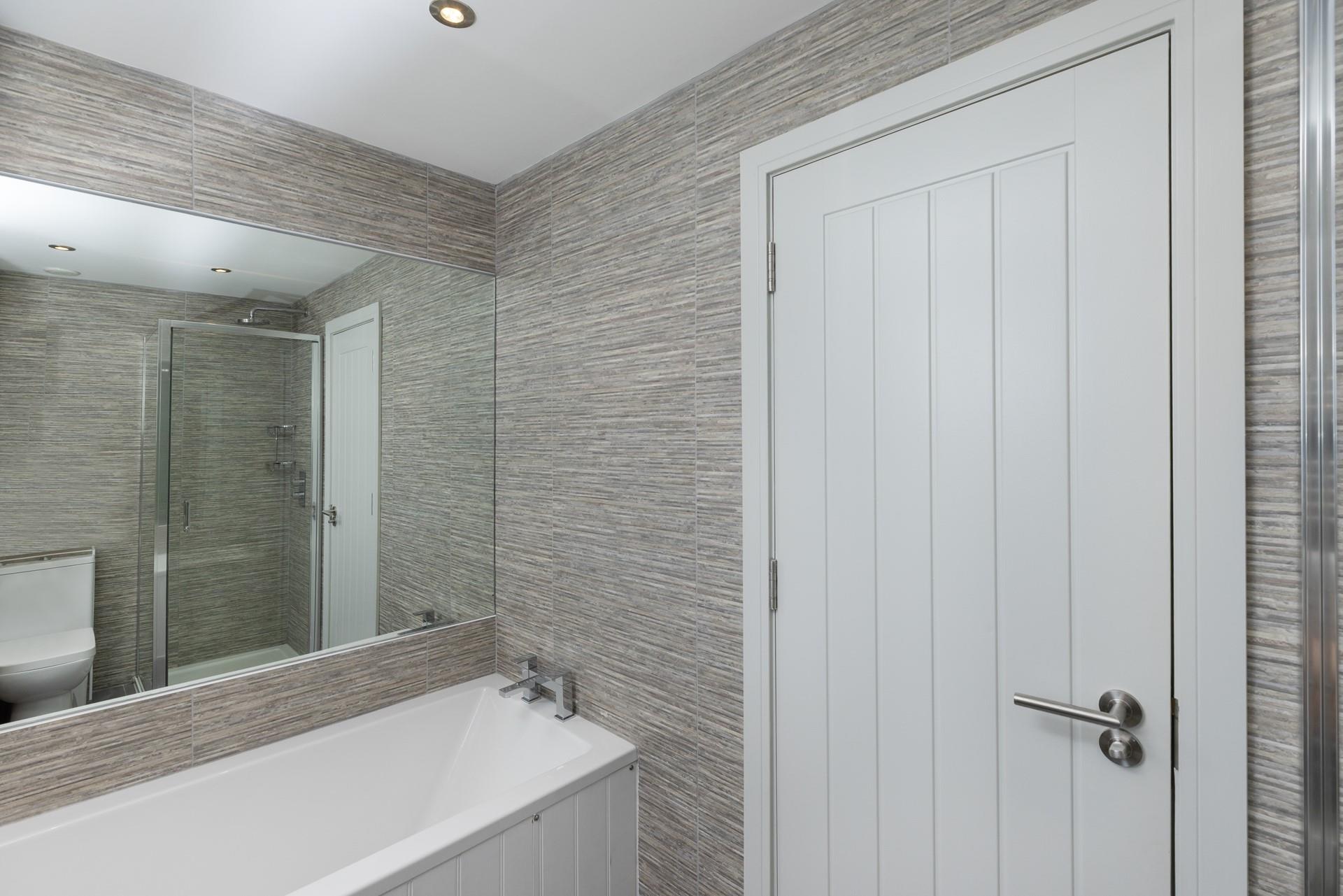 The family bathroom is sleek and stylish with a rainfall shower.