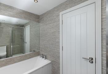 The family bathroom is sleek and stylish with a rainfall shower.