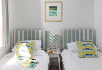 We love the coastal style in the twin bedroom with nautical stripes.