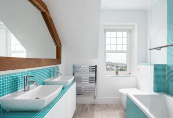 The family bathroom features his and her sinks and a bath, perfect to relax and unwind after a busy day.