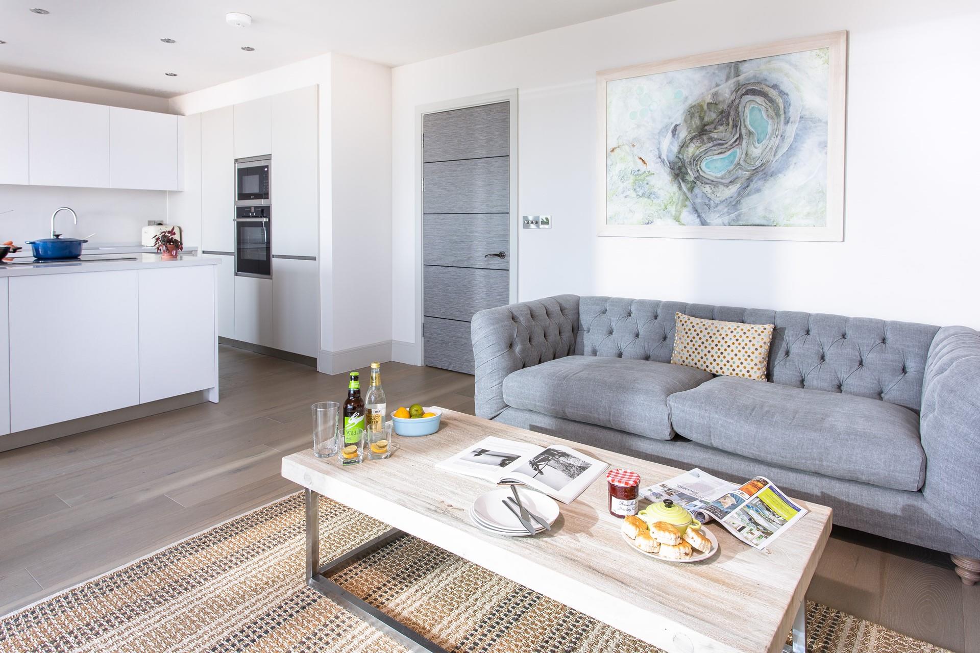 The sitting room is lovely and light, with cool artwork and a comfortable sofa looking out to sea.