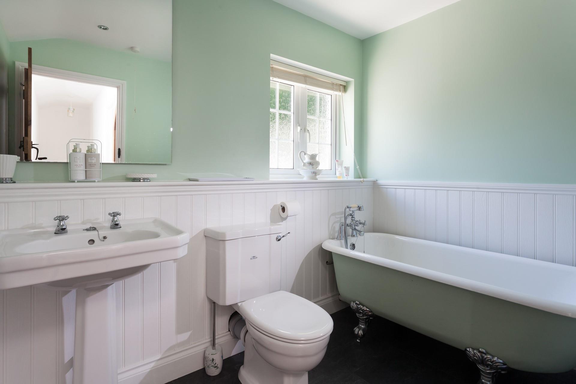 A roll-top bath adds a touch of luxury to the bathroom, perfect for soaking away the sand after a day on the beach!