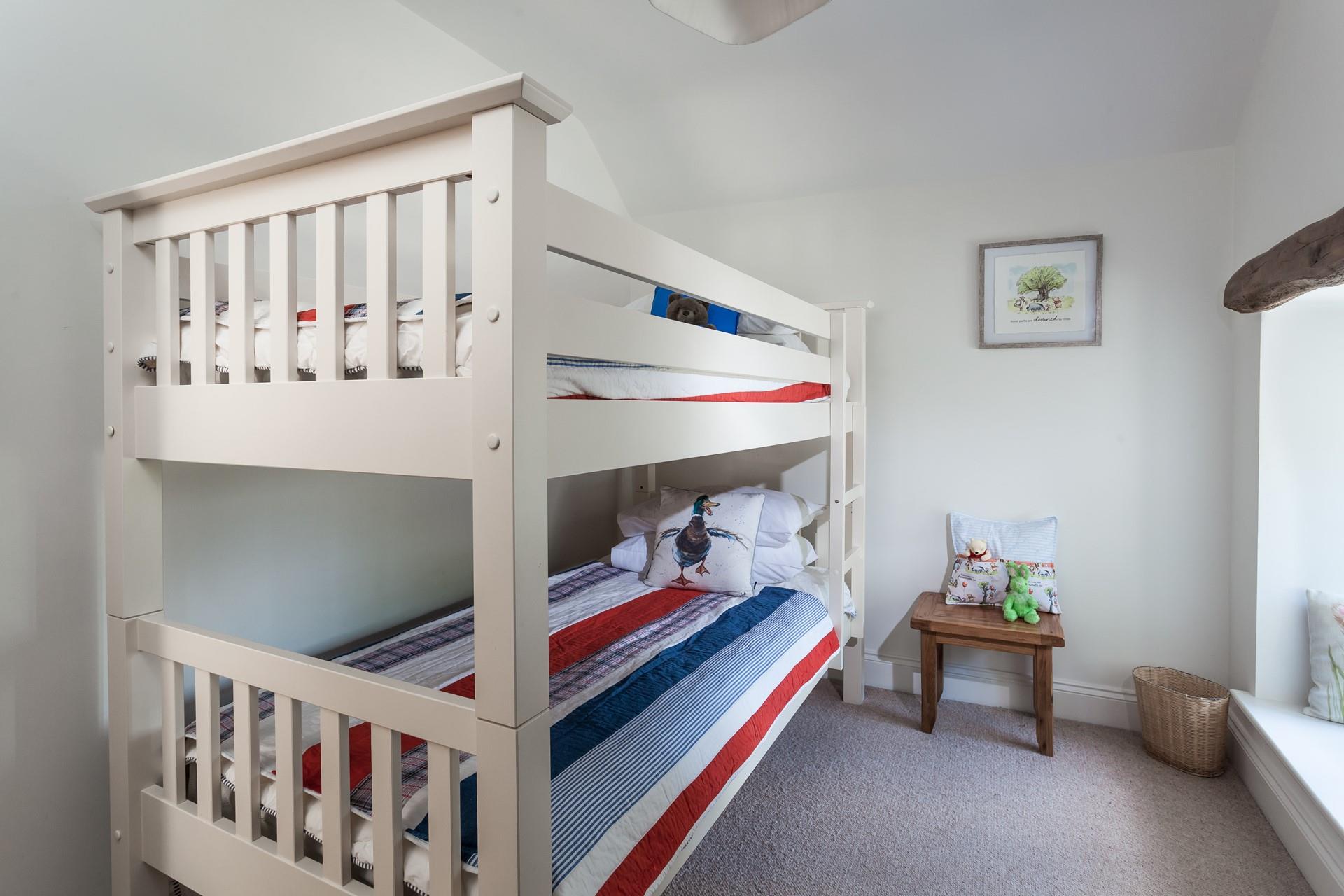 Bunk beds with nautical colours and adorable art are sure to delight younger children!