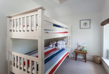 Bunk beds with nautical colours and adorable art are sure to delight younger children!