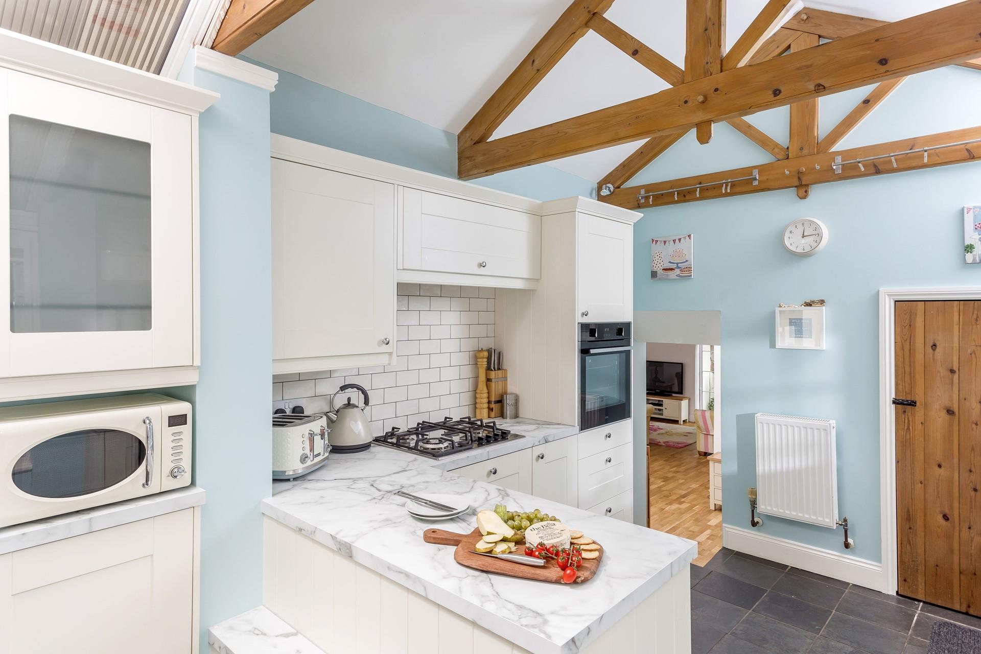The kitchen is decorated in charming pastels and blends traditional features with modern features seamlessly.