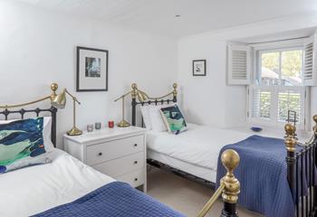 Bedroom 2 has twin beds and is decorated with a pop of colour.