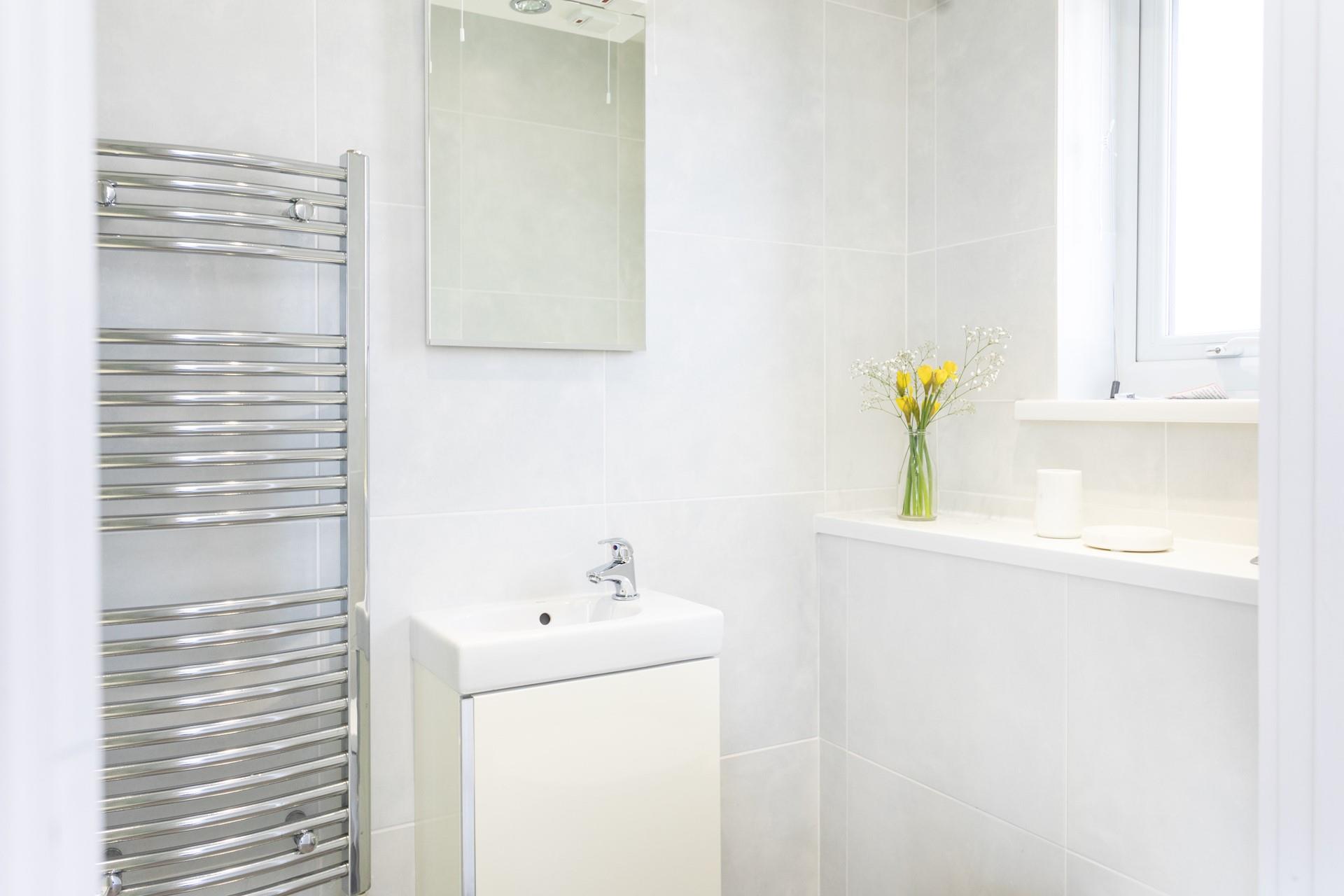 The bathroom is a bright and uncluttered space with sleek and practical furnishings.