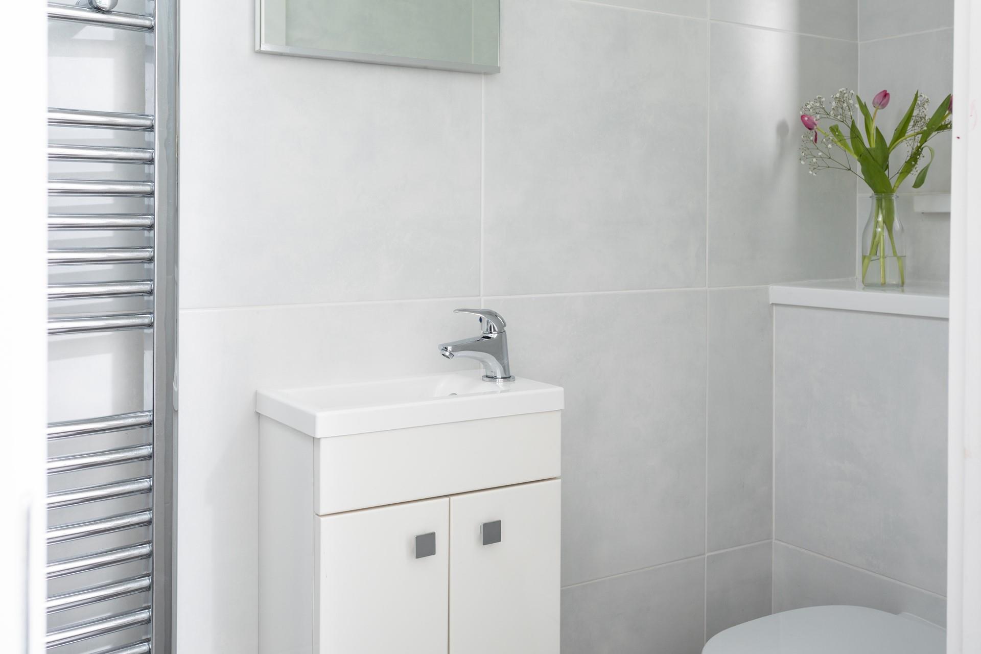 Bright tiles in a classic white make the bathroom a fresh, elegant space.