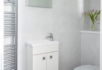 Bright tiles in a classic white make the bathroom a fresh, elegant space.