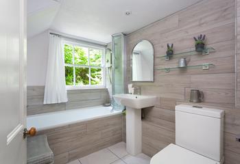 The bathroom is spacious and beautifully designed, offering a stylish place to pamper yourself.