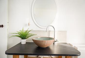 A free-standing sink in earthy tones offers a touch of elegance.