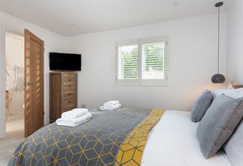 The cosy bedroom boasts a TV and stylish en suite.
