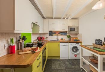 The kitchen has a pop of colour and is fully equipped for cooking tasty meals.