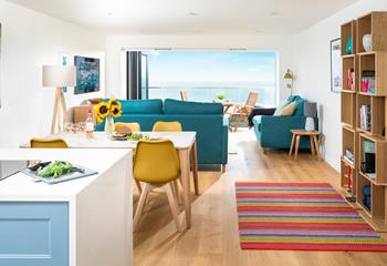 The open plan living space is colourful and bright with soft furnishings making for a relaxing home from home.