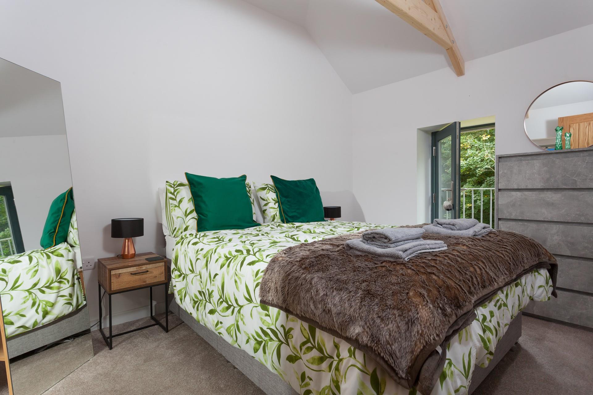 Bedroom 1 has a king size bed and is decorated with a forest green theme.