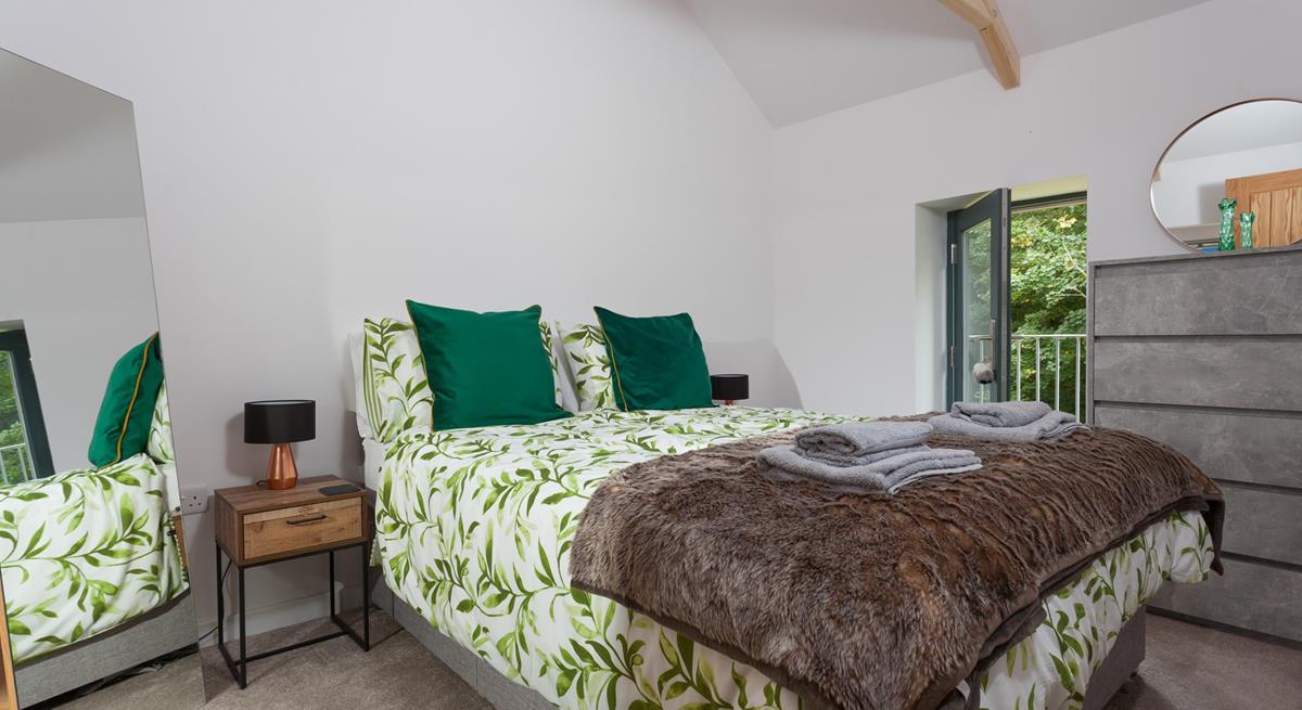 Bedroom 1 has a king size bed and is decorated with a forest green theme.