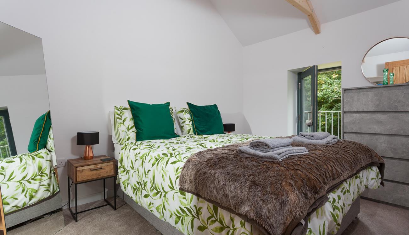 Bedroom 1 has a king size bed and is decorated with a forest green theme.