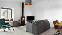The cosy sitting room has a plush grey sofa to relax and unwind after a day of exploring.