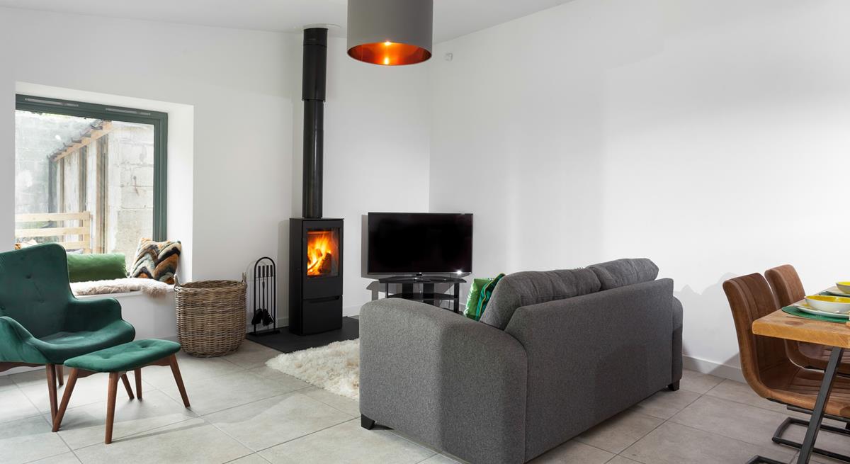 The cosy sitting room has a plush grey sofa to relax and unwind after a day of exploring.