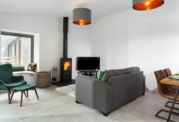 The cosy sitting room has a plush grey sofa to relax and unwind after a day of exploring.