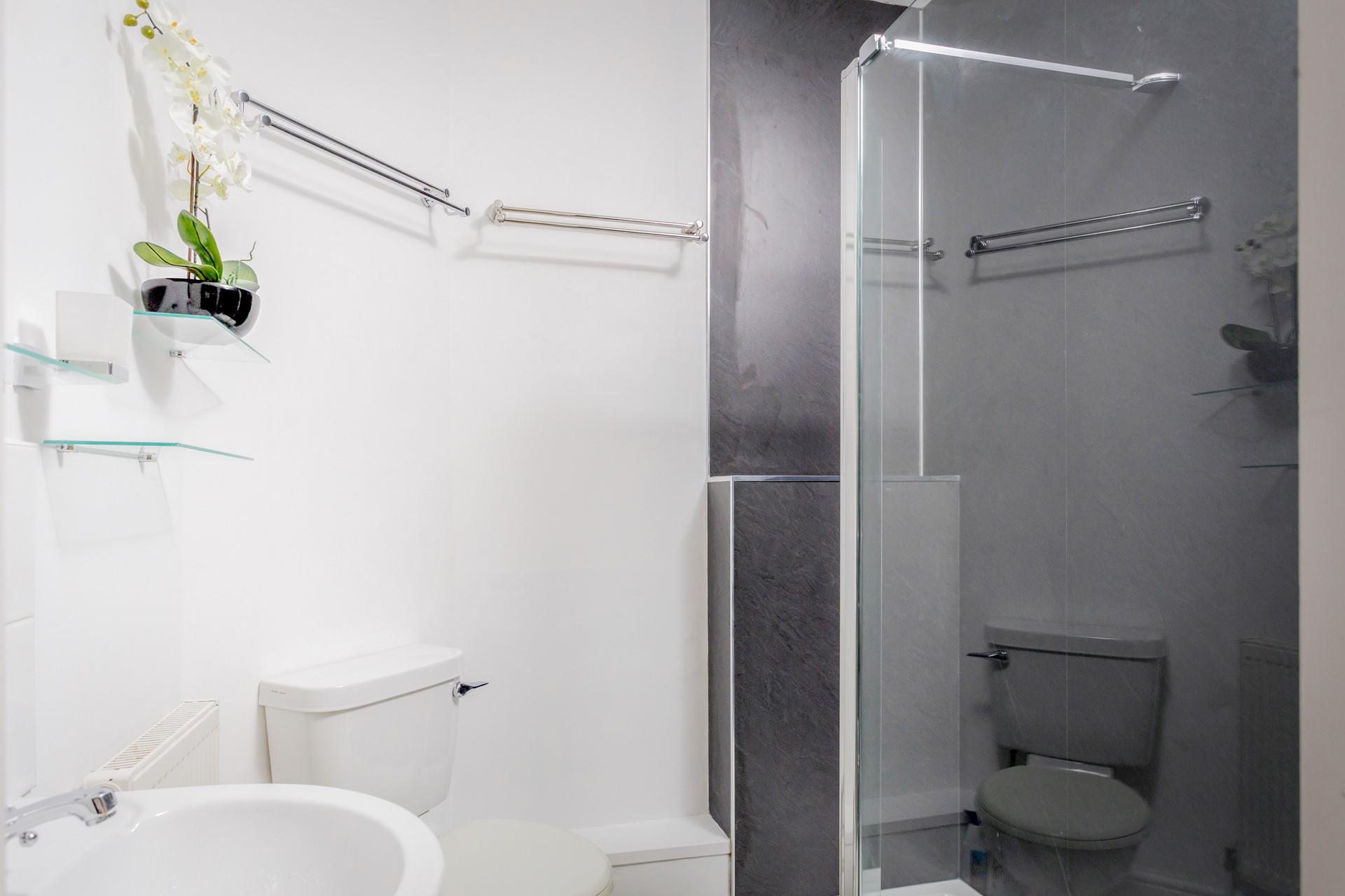 The bathroom has shower, WC and basin with an illuminated mirror over.