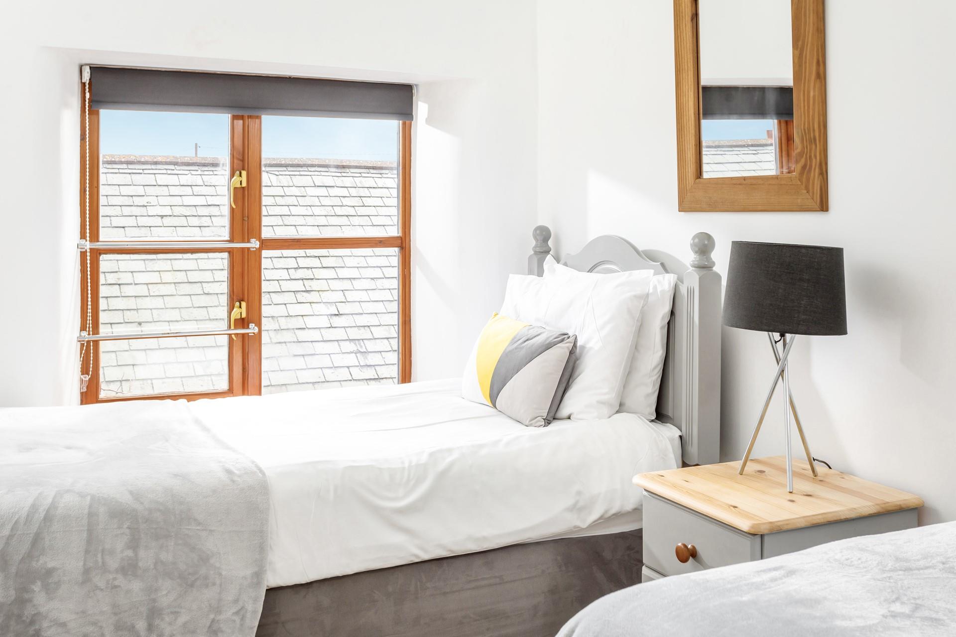 Bedroom 2 has calming grey decor for a relaxing night's slumber.