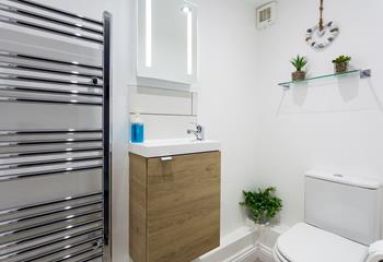 The minimalistic decor and white walls prevent the bathroom from feeling cluttered.