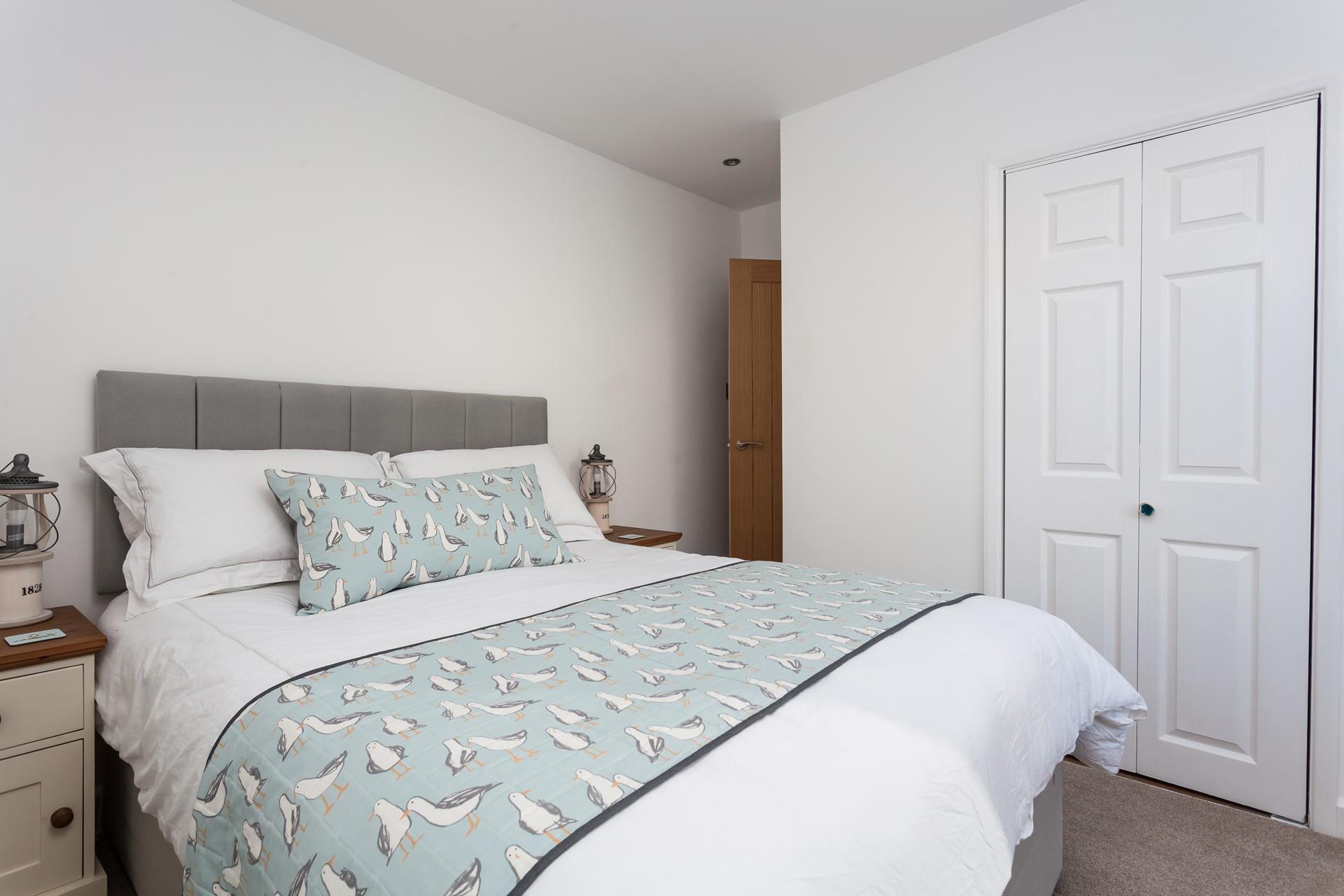 The seaside theme carries into the bedroom with the quirky bedding.