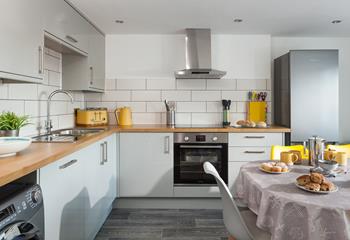 The modern kitchen has a grey and yellow theme and is the ideal space to cook delicious meals.