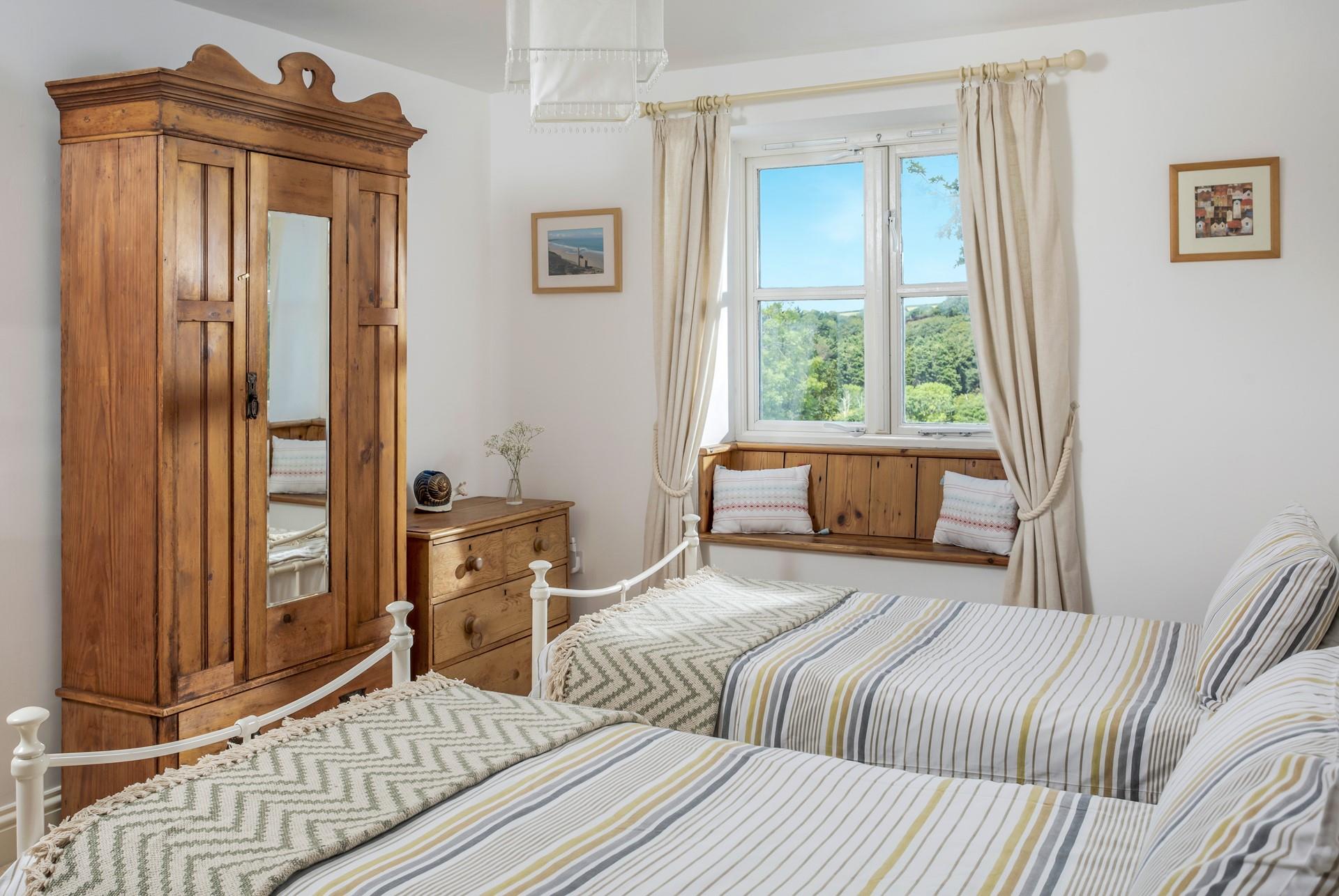 Bedroom 2 offers twin beds and a lovely little window seat for reading a bedtime story. 