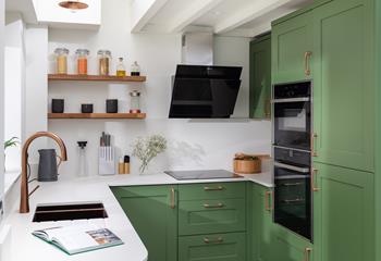 Make yourself at home in the stylish kitchen, finished in a homely shade of green with gorgeous copper accessories. 