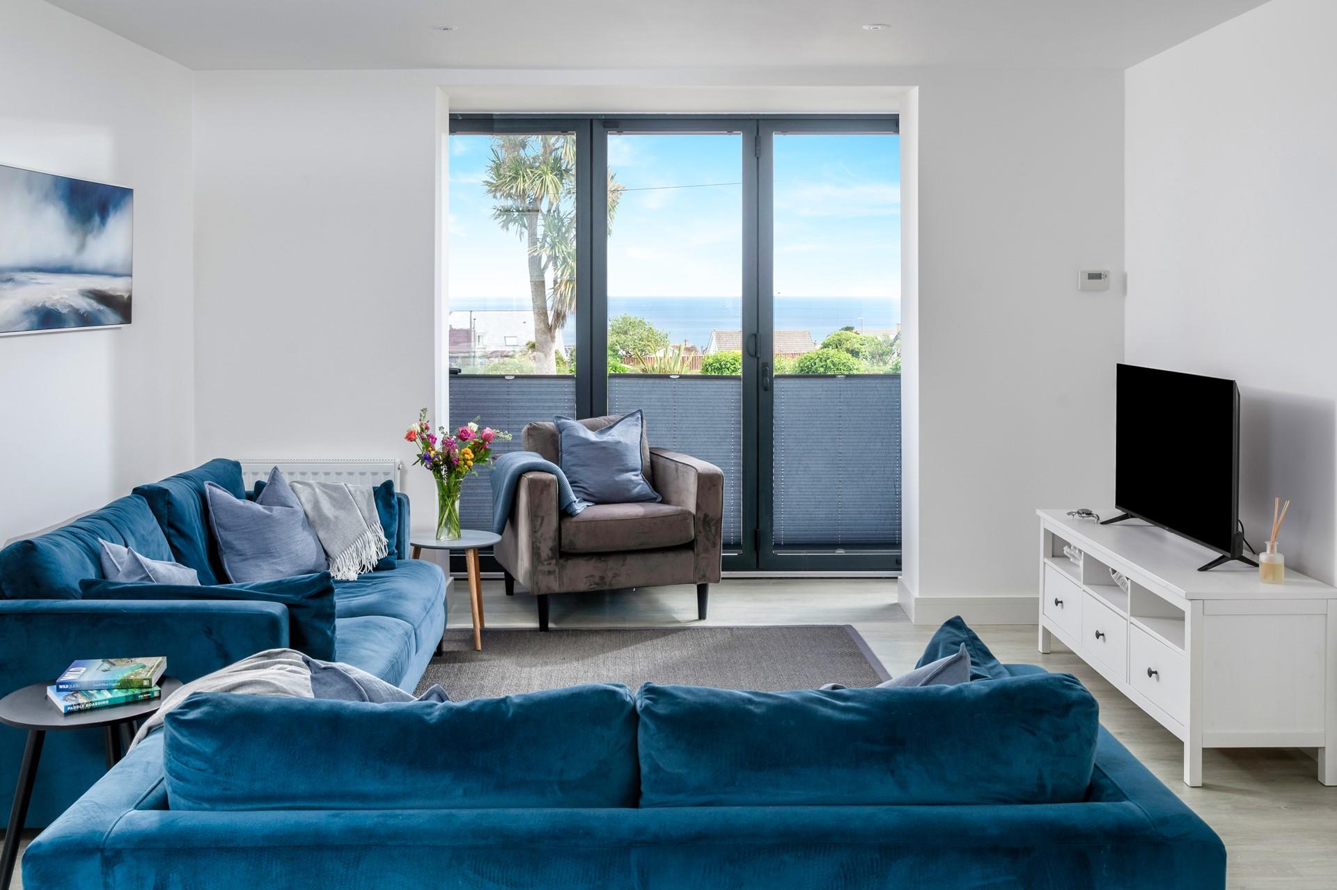 The modern living area has a bright, coastal feel and sea views!