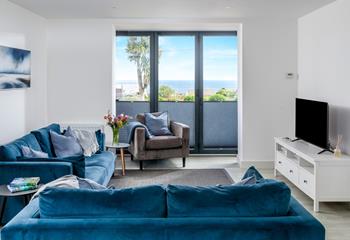 The modern living area has a bright, coastal feel and sea views!