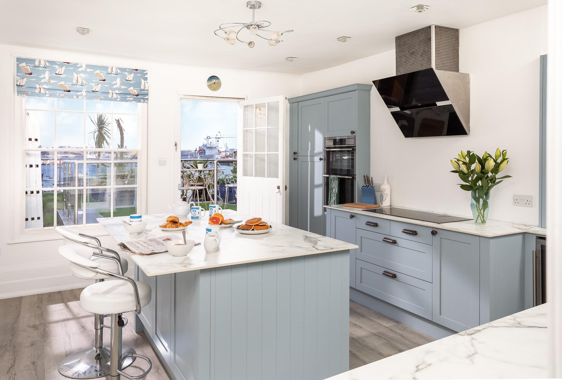Coastal blues continue into the stunning kitchen, offering a sleek and stylish place to cook.
