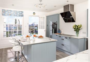Coastal blues continue into the stunning kitchen, offering a sleek and stylish place to cook.