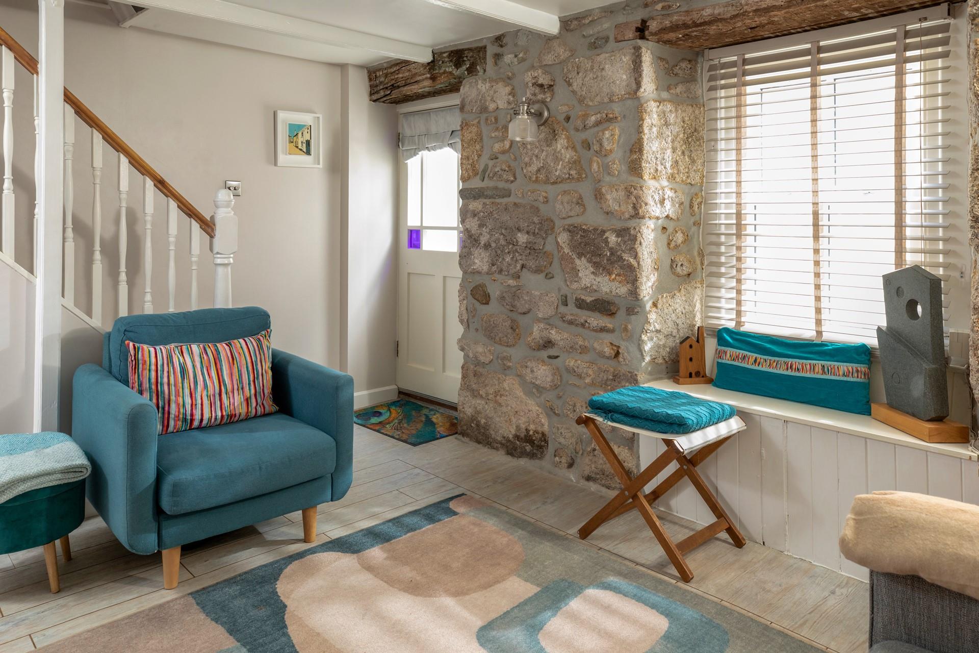 Beautifully finished with bold blues and striking coastal artwork, the sitting room echoes Trelither's seaside location. 