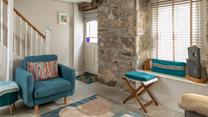 Beautifully finished with bold blues and striking coastal artwork, the sitting room echoes Trelither's seaside location. 