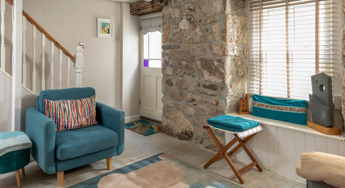 Beautifully finished with bold blues and striking coastal artwork, the sitting room echoes Trelither's seaside location. 