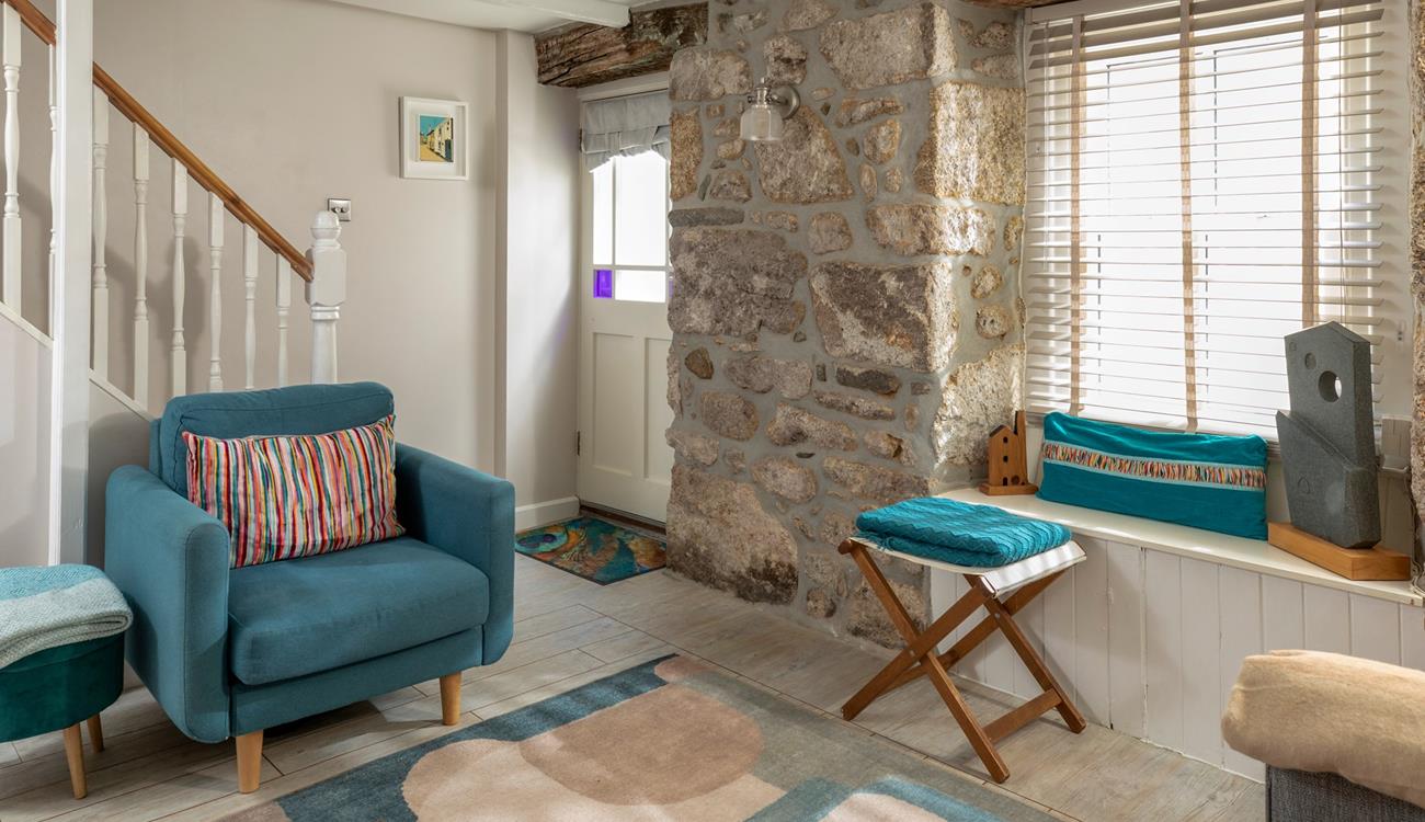 Beautifully finished with bold blues and striking coastal artwork, the sitting room echoes Trelither's seaside location. 