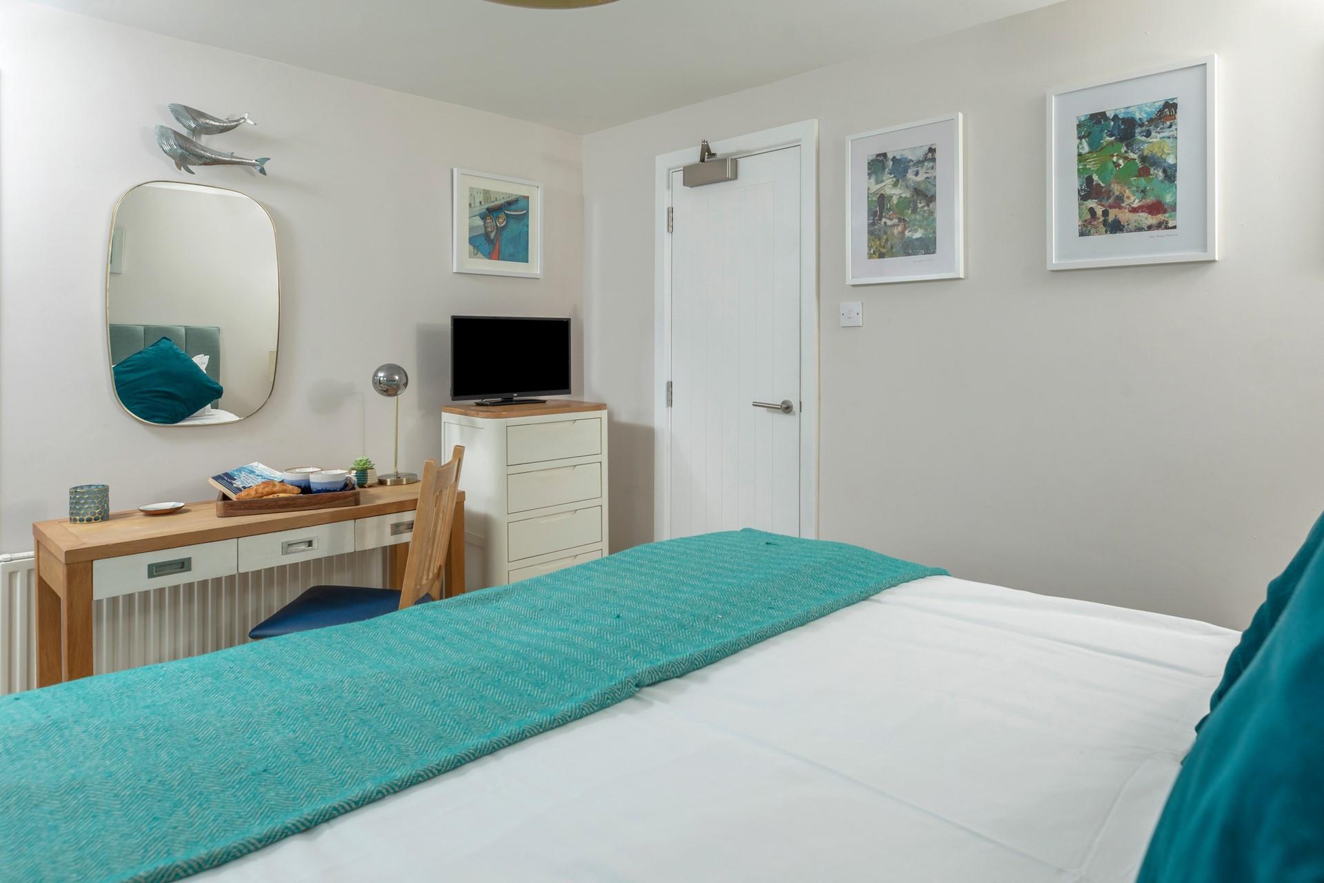 The unique lamp and teal colour scheme adds a sense of luxury to the room. 