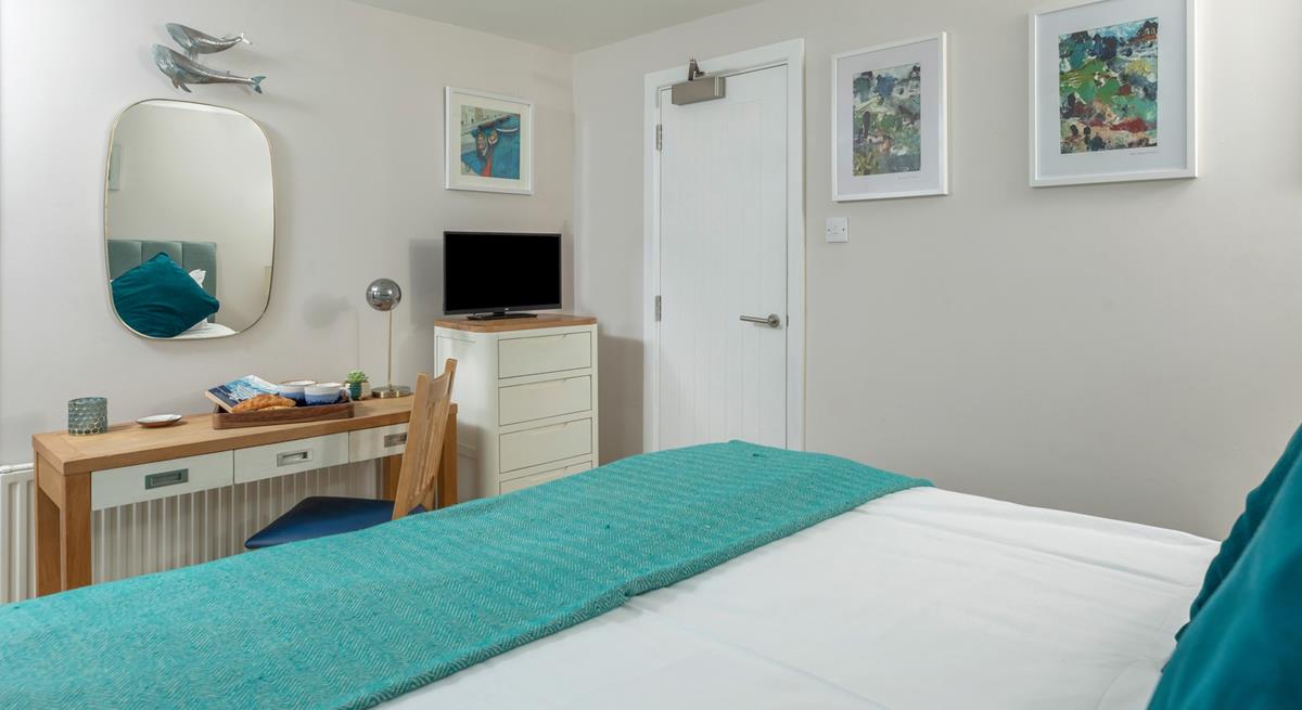 The unique lamp and teal colour scheme adds a sense of luxury to the room. 