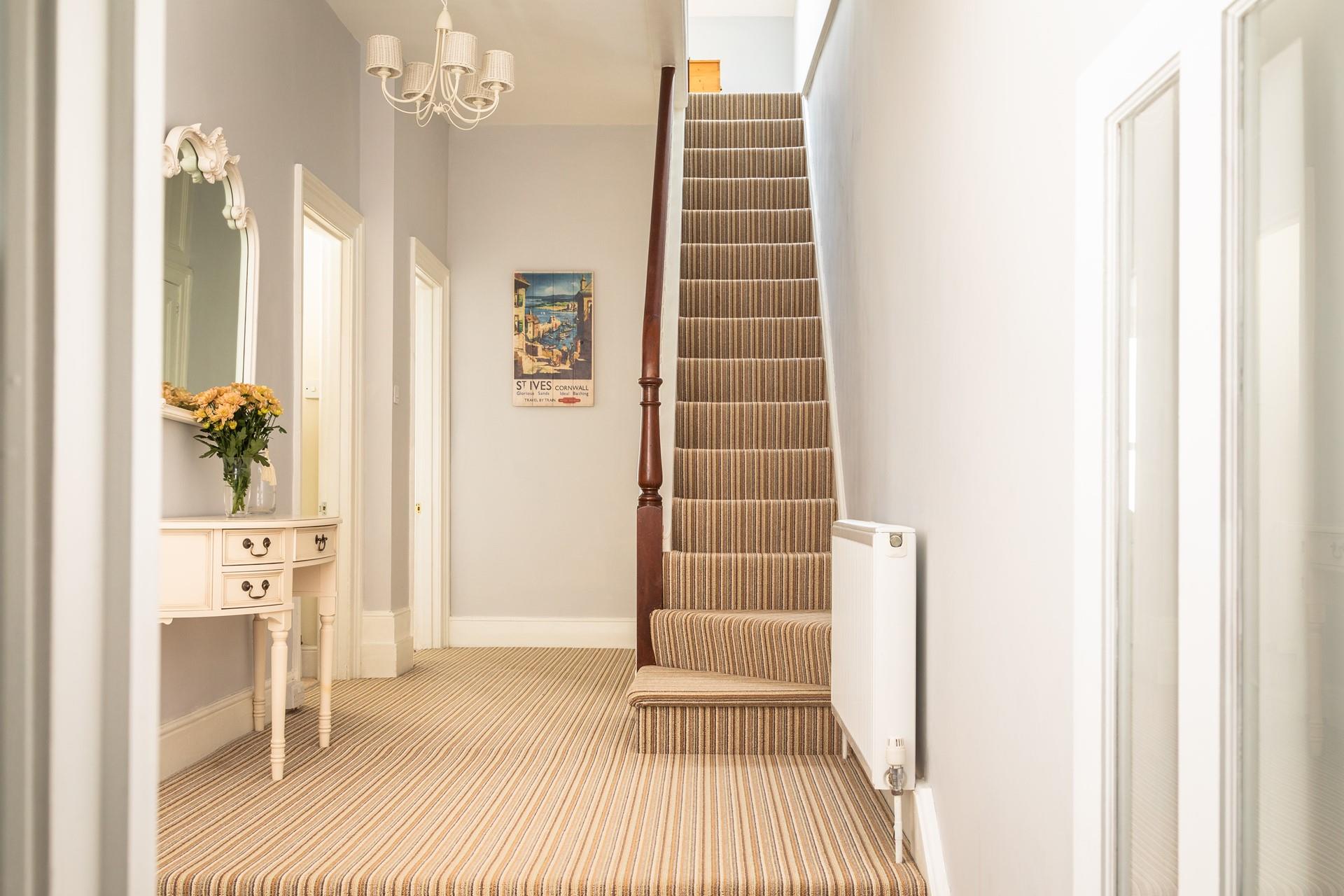 The spacious hallway is split-level, with doors to the cloakroom, bedroom 1 and sitting room. 
